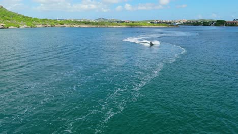 Drone-Orbita-Alrededor-De-Una-Pareja-Aventurera-En-Motos-De-Agua-Navegando-En-La-Bahía-De-Aguas-Del-Caribe