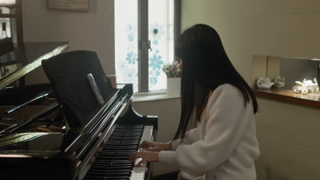 Asian-girl-practicing-piano-at-home