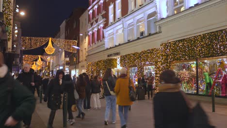 Einkaufsviertel-Mit-Verbrauchern-In-Der-Nacht-Mit-Weihnachtsbeleuchtung-Im-Dezember,-Dublin,-Irland