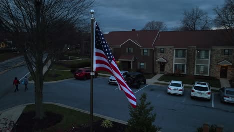 American-flag-waving-in-front-of-townhomes-in-USA-suburb