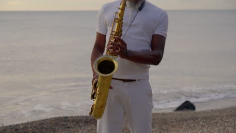 Man-Playing-Saxophone-on-Seashore-at-Dusk