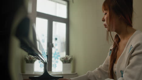 Woman-playing-piano-at-home-in-cosy-warm-environment