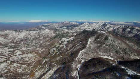 Luftaufnahme-Von-Schneebedeckten-Bergen-Und-Einem-Gefrorenen-Wald,-Majestätische-Schönheit-Eines-Kalten-Winterwunderlandes