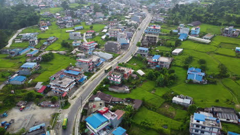 Aerial-tilt-Up-shot-showing-Pokhara-City-of-with-main-road-and-old-buildings-with-blue-colored-roofs-in-Nepal