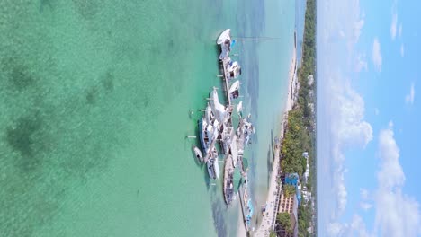 Vuelo-Vertical-De-Drones-Sobre-Yates-De-Lujo-Estacionados-En-El-Muelle-De-La-Playa-De-Boca-Chica-Con-Agua-Clara-Del-Mar-Caribe