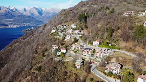 Cozy-mountain-village-and-lake-Como-in-background,-aerial-view