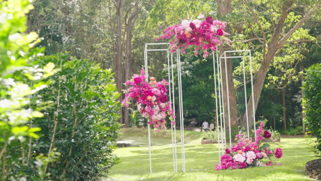 Slow-Motion-Reveal-From-Green-Bush-To-Colorful-Floral-Wedding-Arbour-In-Garden