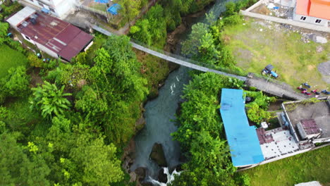 Aerial-top-down-shot-of-flowing-river-with-bridge-in-Pokhara-City-during-sunny-day,-Nepal