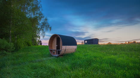 A-trailer-or-tiny-house-and-sauna-in-a-countryside-meadow-as-the-seasons-transition---summer,-autumn,-winter-time-lapse