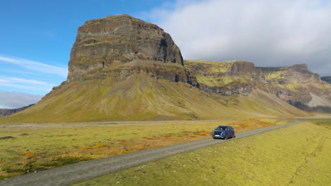 Conducción-De-Automóviles-Con-La-Montaña-Lómagnúpur-Al-Fondo-En-Islandia---Retroceso-Aéreo