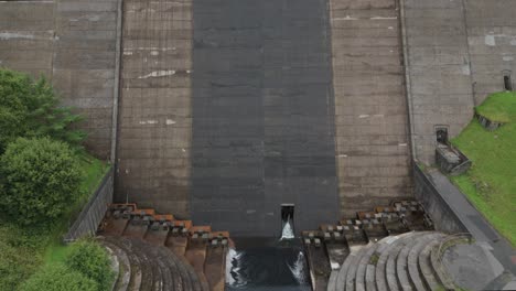 Booth-wood-reservoir-aerial-view-descending-tilt-up-concrete-dam-spillway-construction-in-West-Yorkshire,-England