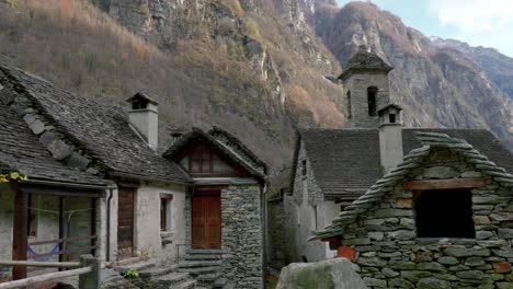 Panorámica-De-Derecha-A-Izquierda-Del-Encuadre,-Que-Muestra-Las-Casas-De-Piedra-De-Cavergno-Y-Las-Montañas-Detrás,-En-El-Distrito-De-Vallemaggia,-En-El-Cantón-De-Ticino,-En-Suiza