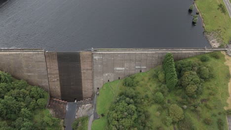 Booth-wood-reservoir-aerial-view-dolly-across-concrete-dam-spillway-and-fresh-water-lake,-West-Yorkshire