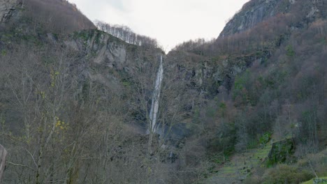 Tilting-drone-shot-of-Cascata-di-Foroglio-Waterfall,-located-in-the-village-of-Cavergno,-in-the-district-of-Vallemaggia,-a-canton-of-Ticino,-in-Switzerland