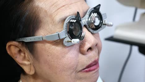 Ältere-Frau,-Die-In-Einer-Optischen-Klinik-In-Bangkok,-Thailand,-Einen-Sehtest-Zur-Überprüfung-Ihrer-Sehschärfe-Durchführt