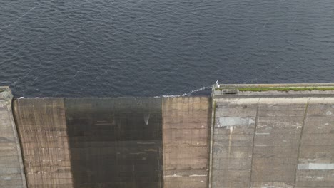 Booth-wood-reservoir-aerial-view-close-up-on-lake-water-supply-splashing-over-concrete-dam-spillway-gate