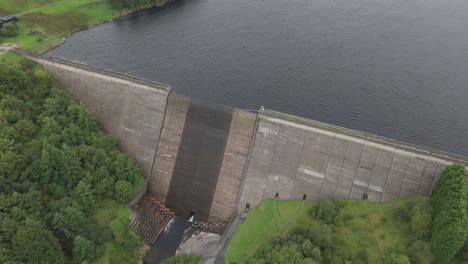 Booth-wood-reservoir-aerial-view-flyover-of-concrete-dam-spillway-and-fresh-water-lake,-West-Yorkshire