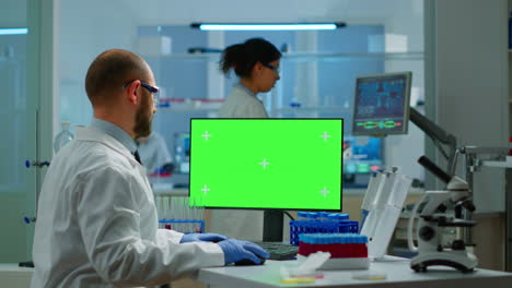 Man-researcher-looking-at-chroma-key-display-of-computer