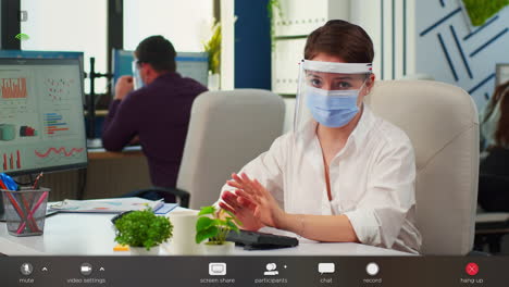 Businesswoman-with-visor-and-mask-talking-in-front-of-camera