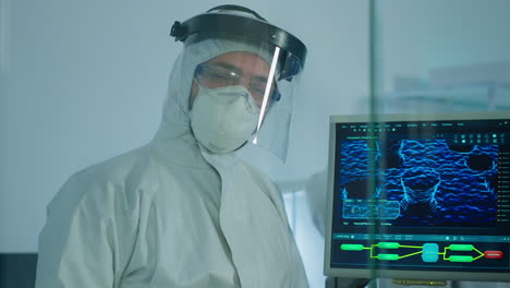 Microbiologist-in-ppe-suit-standing-in-laboratory-looking-at-camera