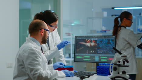 Team-medical-scientist-conducting-DNA-experiments-looking-in-computer