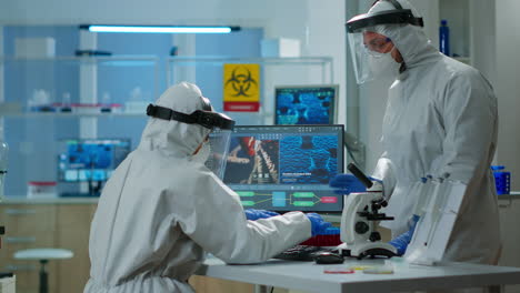Chemist-woman-in-ppe-suit-typing-on-pc-checking-virus-development