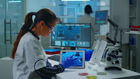 Lab-technician-doctor-analyzing-virus-evolution-looking-on-digital-tablet