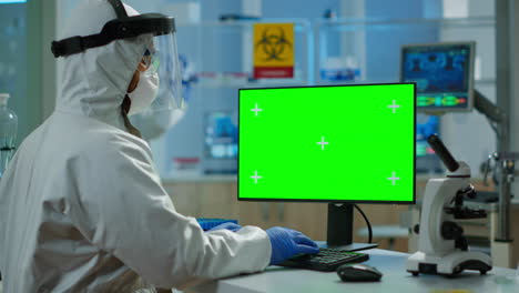 Man-researcher-in-coverall-looking-at-chroma-key-computer