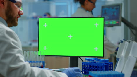 Mann-Arzt-Arbeitet-Am-PC-Mit-Grünem-Bildschirm-In-Einem-Modern-Ausgestatteten-Labor