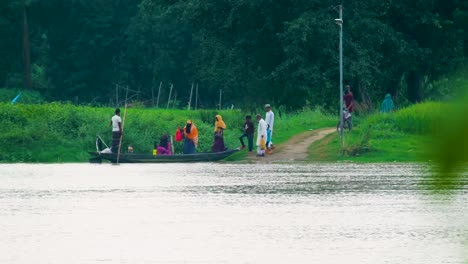 Village-people-embarking-on-wooden-boat-to-cross-river-in-Bangladesh