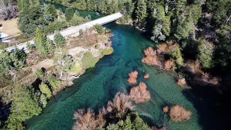 Powerful-forest-river-and-man-made-bridge,-aerial-view