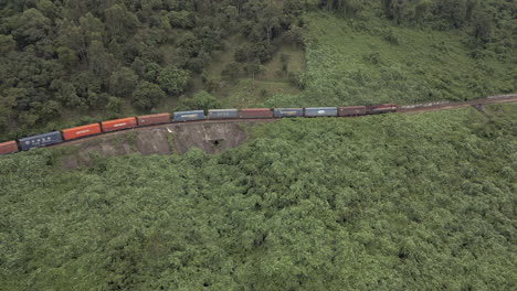 Train-Engine-Tows-Cargo-Along-Steep-Mountain-Pass-Drone-Pull-Back