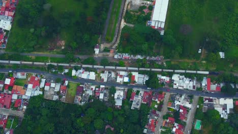 beautiful-aerial-view-with-drone-of-the-passing-of-the-train-on-the-city-of-Cordoba,-Veracruz,-Mexico