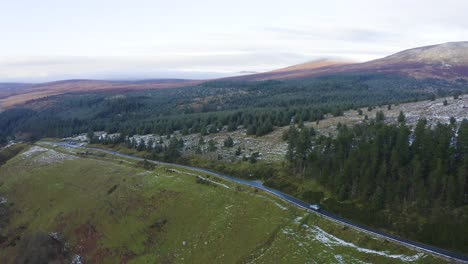 Journey-Through-Wicklow:-Aerial-Tracking-of-a-Gray-Car-Amidst-Misty-Mountains-and-Snow-Covered-Forests