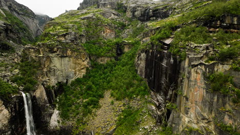 Scenic-aerial-view-of-falls-over-cliffside-in-Hellmojuvet-alpine-canyon,-Norway