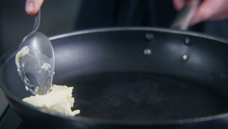 Chefkoch-Legt-Butter-In-Die-Bratpfanne-Auf-Dem-Herd