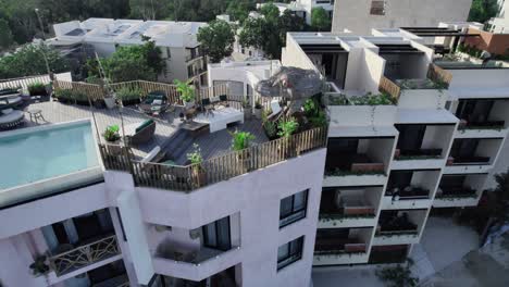 Aerial-over-decorated-balconies-on-residential-building,-flower-pots-and-chairs-for-leisure-time-at-rooftop