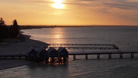 Drone-captures-sunset-with-low-cloud-against-Busselton-Jetty-in-Margaret-River,-Western-Australia
