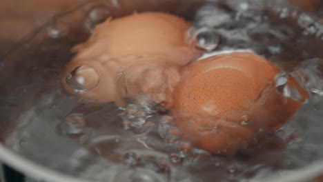 Dos-Huevos-Hirviendo-En-Una-Olla-Con-Agua-Burbujeante