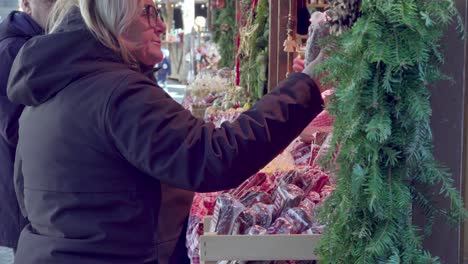 Besucher-Des-Weihnachtsmarktes-Zeigen-Und-Begutachten-Die-Ausgestellten-Waren