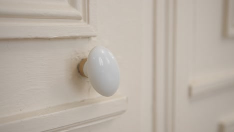 Moving-door-knob-of-a-white-door,-scary-and-mysterious