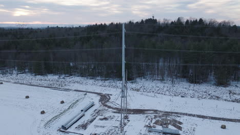 Electrical-Power-Lines-in-a-Snowy-Winter-Forest,-Aerial