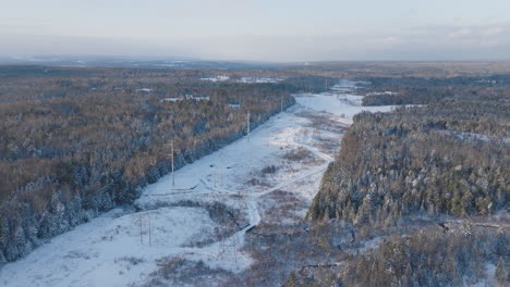 Aerial-Panorama-of-High-Voltage-Electrical-Power-Lines-in-a-Winter-Forest