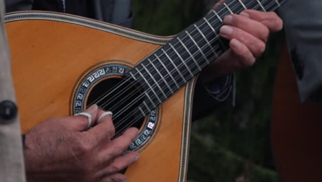 Strumming-a-Portuguese-guitar-outdoors.-Close-up