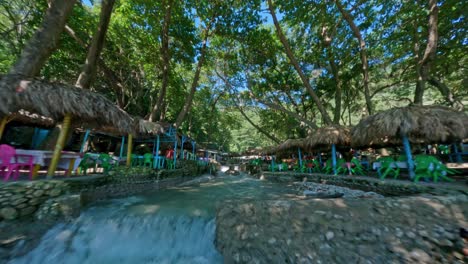 FPV-flight-over-river-with-playing-Kids-and-restaurant-at-BALNEARIO-SAN-RAFAEL-in-Barahona