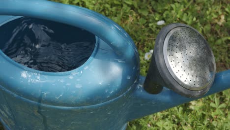 A-person-sets-down-a-watering-can-full-of-water,-gardening