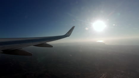 Fly-over-Malaga,-Spain,-Ryan-Air-plane-wing-over-Mediterranean-Sea
