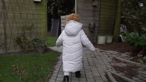Toddler-running-in-beautiful-big-garden-with-a-thick-winter-jacket-for-the-cold