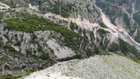 Vista-De-Drones-En-Albania-Volando-Sobre-Una-Montaña-Verde-Y-Rocosa-Desde-La-Vista-Superior