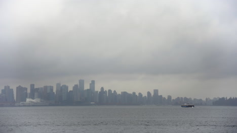 Ein-Weites-Panorama-Der-Skyline-Von-Vancouver,-Eingehüllt-In-Eine-Düstere-Wolkendecke,-Mit-Dem-In-Der-Ferne-Auftauchenden-Seebus-Und-Einem-Flinken-Motorboot,-Das-Energisch-Im-Vordergrund-Rast